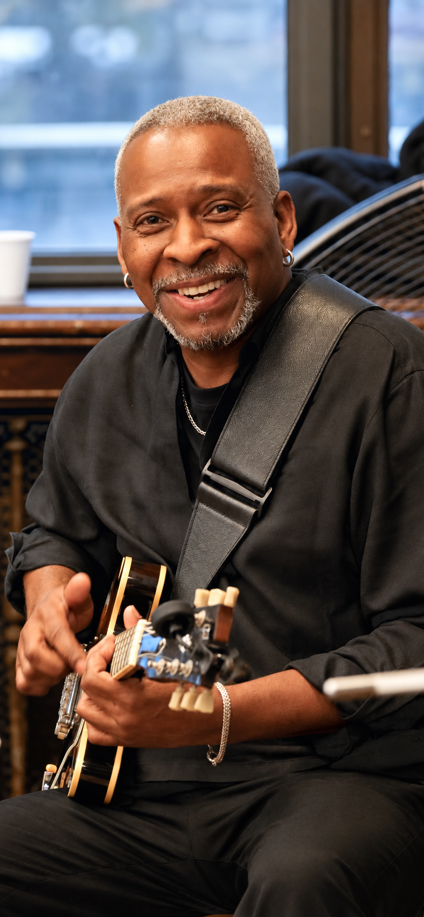 Wil A. Crosby seated with his guitar
